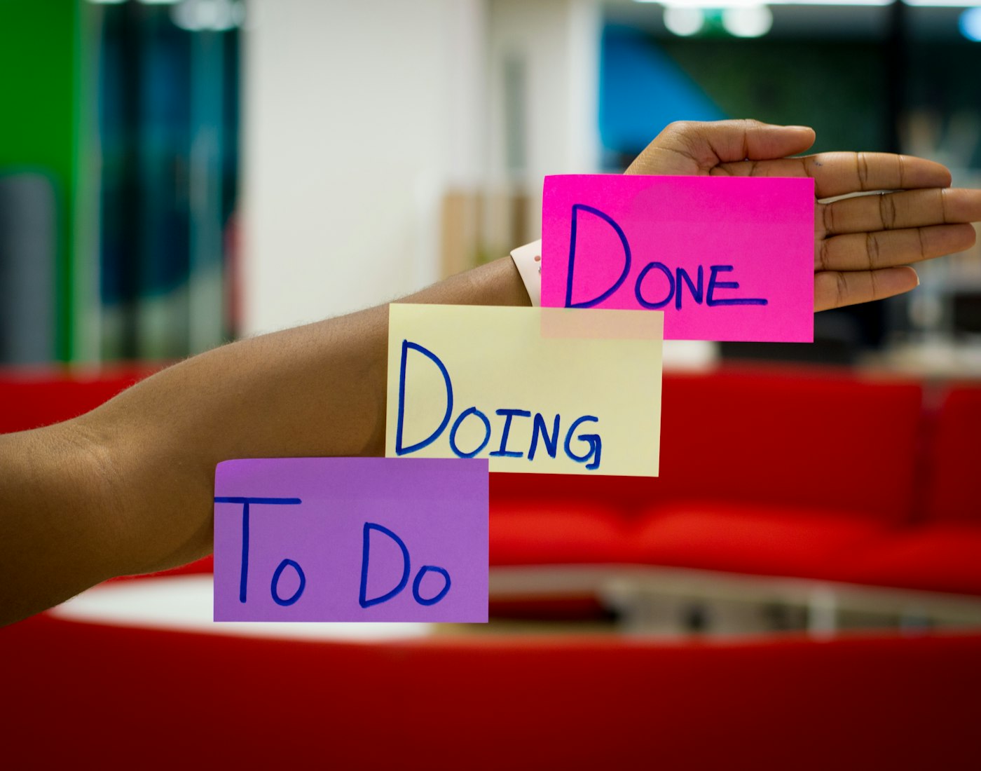 Sticky notes labeled To Do, Doing and Done held up during a planning session