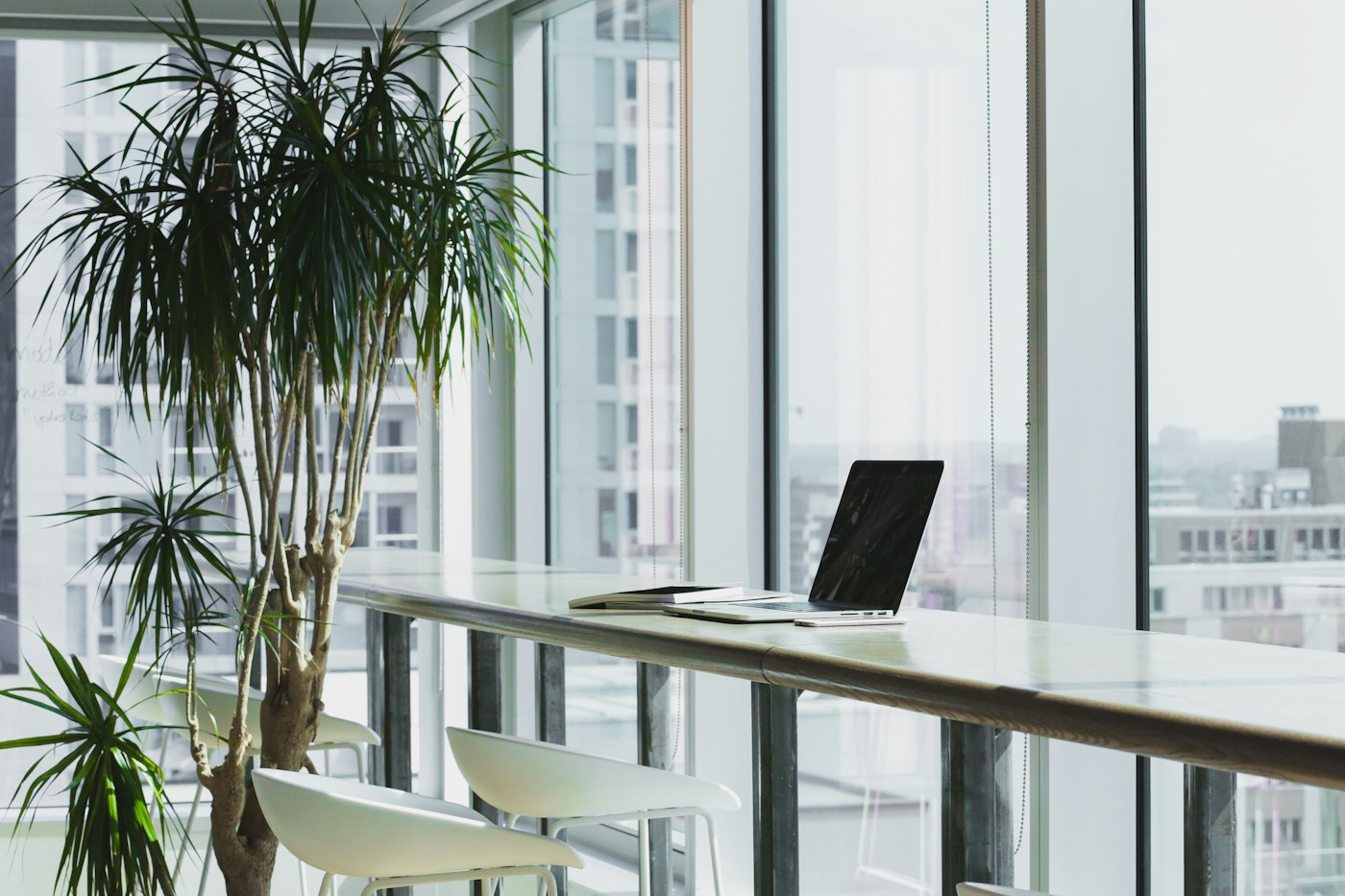 Sunlit meeting space with a laptop on a long table