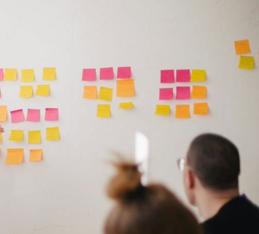 Workshop whiteboard organized with colorful sticky notes
