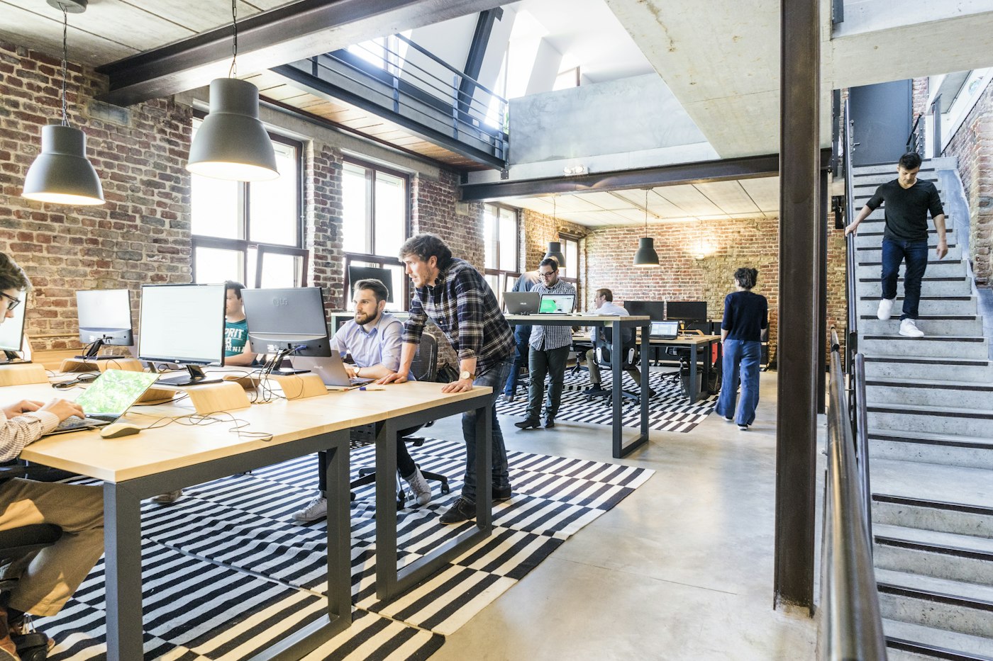 Bright startup workspace with people working at long desks